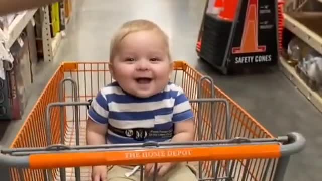 Baby adorable laughing while riding on trolley
