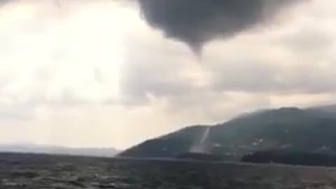 Beachgoers witness waterspout funnel cloud