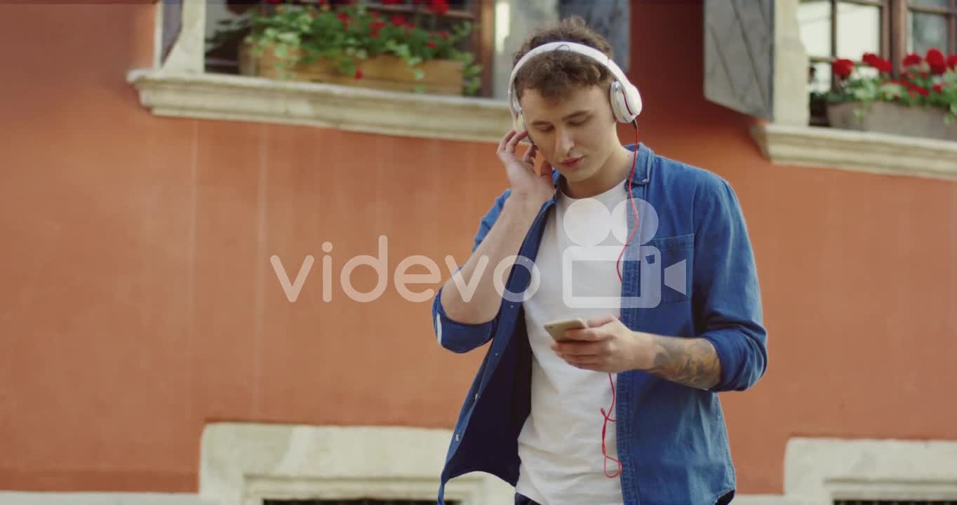Stylish Guy Listeling To Music And Walking In The Street