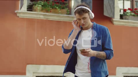 Stylish Guy Listeling To Music And Walking In The Street