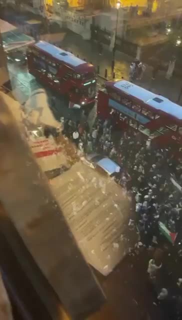 Palestine supporters swarm the streets around Parliament and begin banging on vehicles.