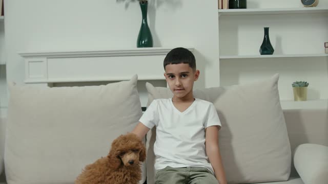 A Boy Petting His Dog While Sitting in a Couch