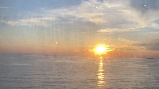 Sunset View Behind the Window of a Ferry
