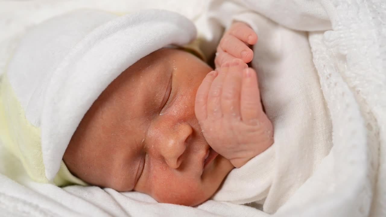 Newborn baby dreaming, face close up