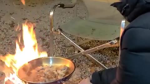 Grilling meat over firewood