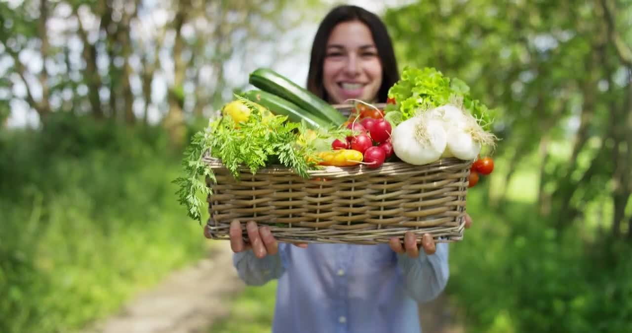 beautiful young girl holding a basket of vegetables in the background of nature con free stock video