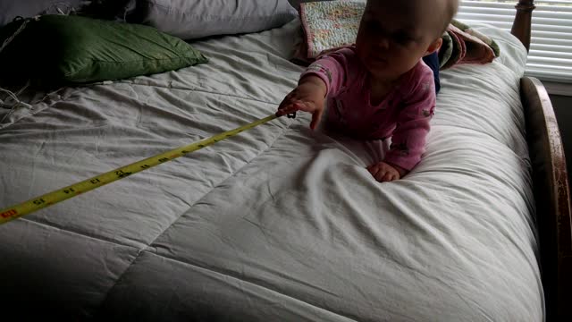 Baby laughs hysterically at measuring tape