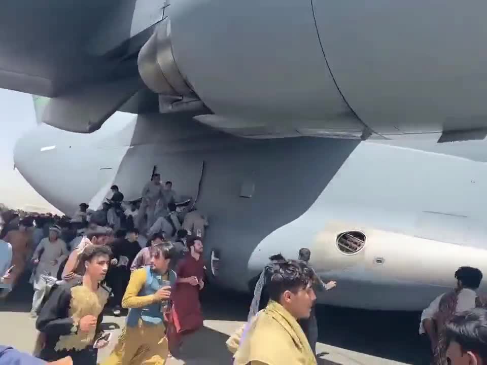 People hanging on to plane at Kabul airport.