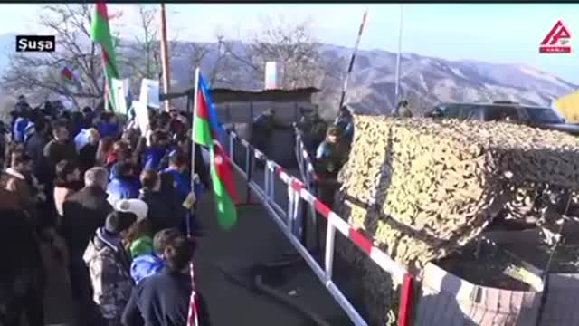 Azeri protesters allow a Russian peacekeeping mission truck through the corridor