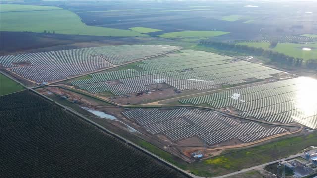 giant solar plant spain with green fields around aerial renewable energy