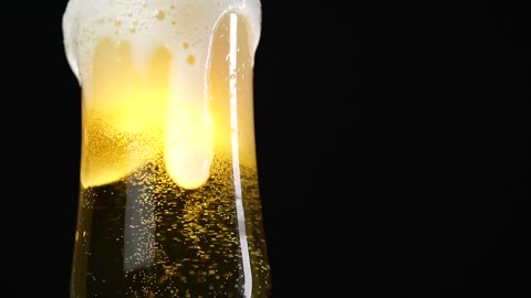 Glass of beer on a black background, in detail