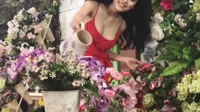 Beauty girl is watering the flowers