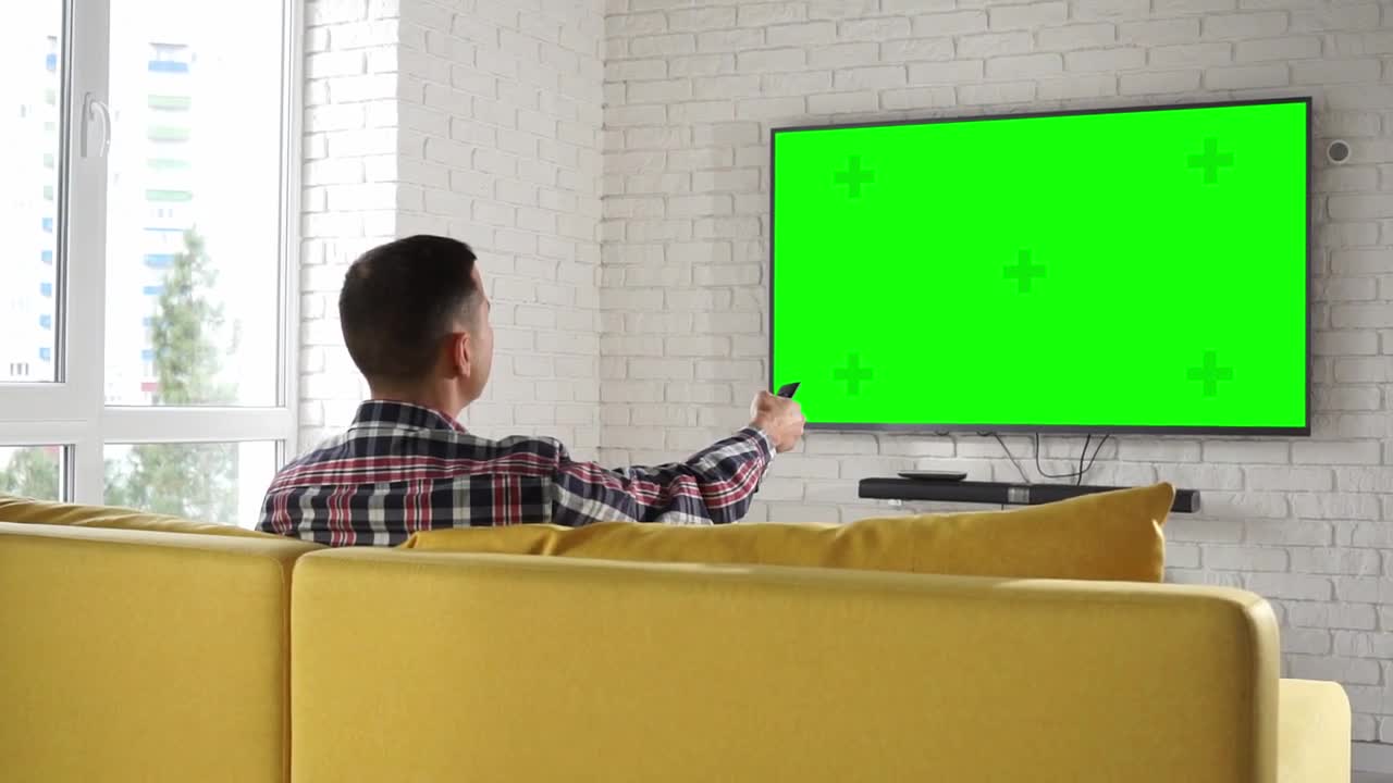 Man Watches Tv Set Green Screen _ Free Video Stock Footage _ Creator Stockify