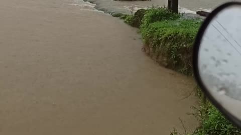 Excavator Returning to Shore Wades Against Floodwaters