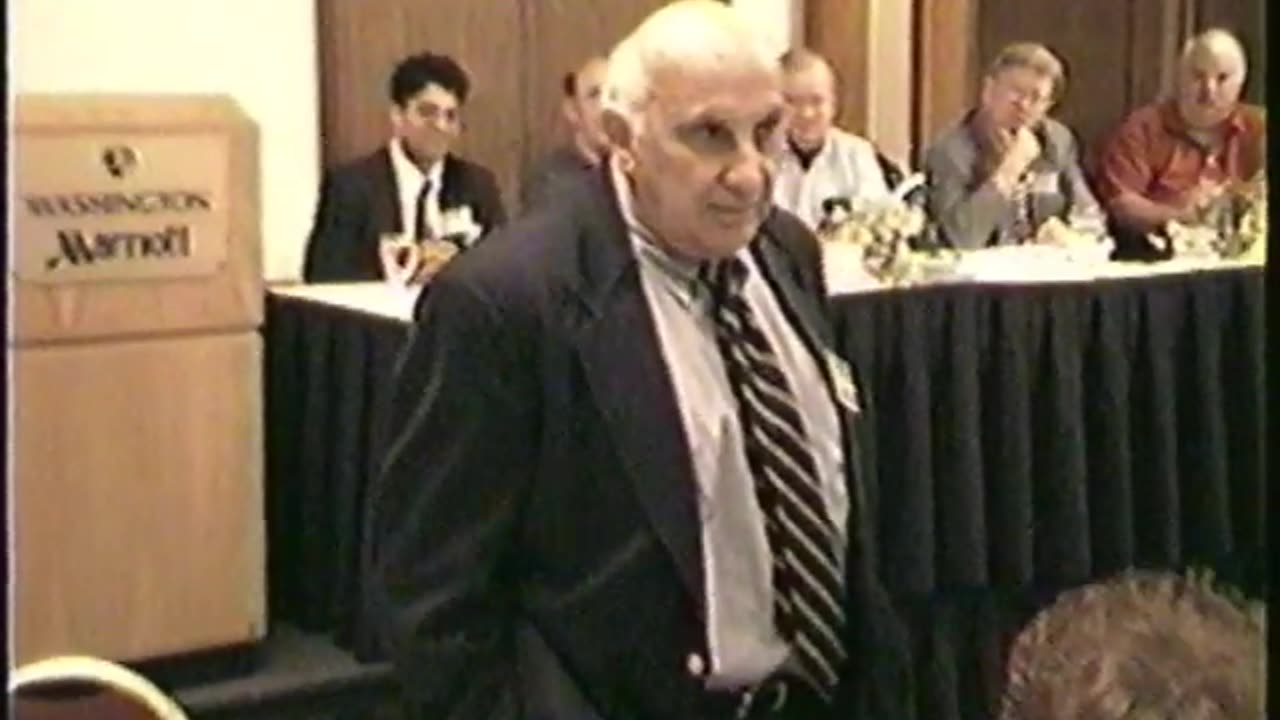 Irwin Schiff speaks in 2002 with Freedom Law School President Peymon Mottahedeh in the background