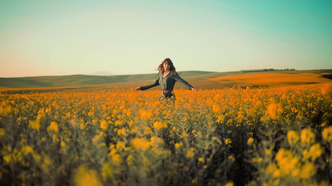 a woman dancing happily in the middle of the field