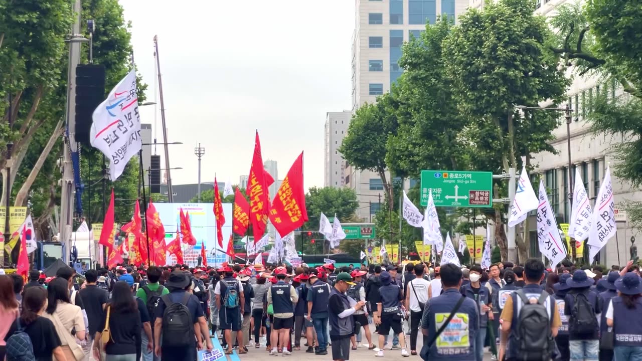 Workers march in protest with flags in Seoul, South Korea, July 15, 2023