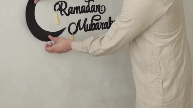 a-man-pasting-a-paper-moon-on-the-wall