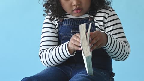 a-young-girl-reading-books-sitting-on-the-floor