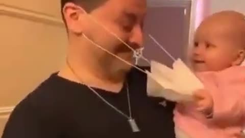 baby play with her father mask