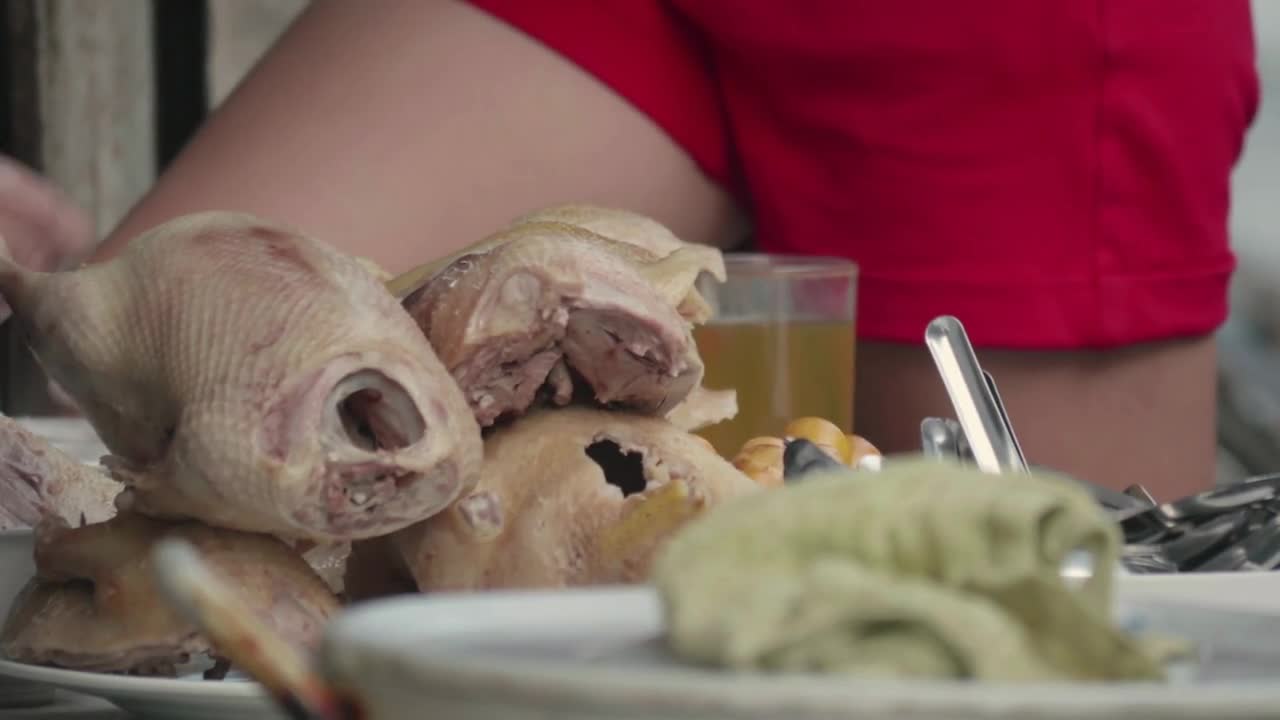 Close-up shot of table with ducks, drinks and tableware in the street