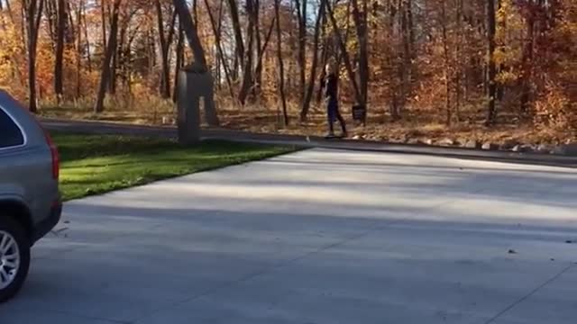 Skateboarding girl in black shirt falls on driveway