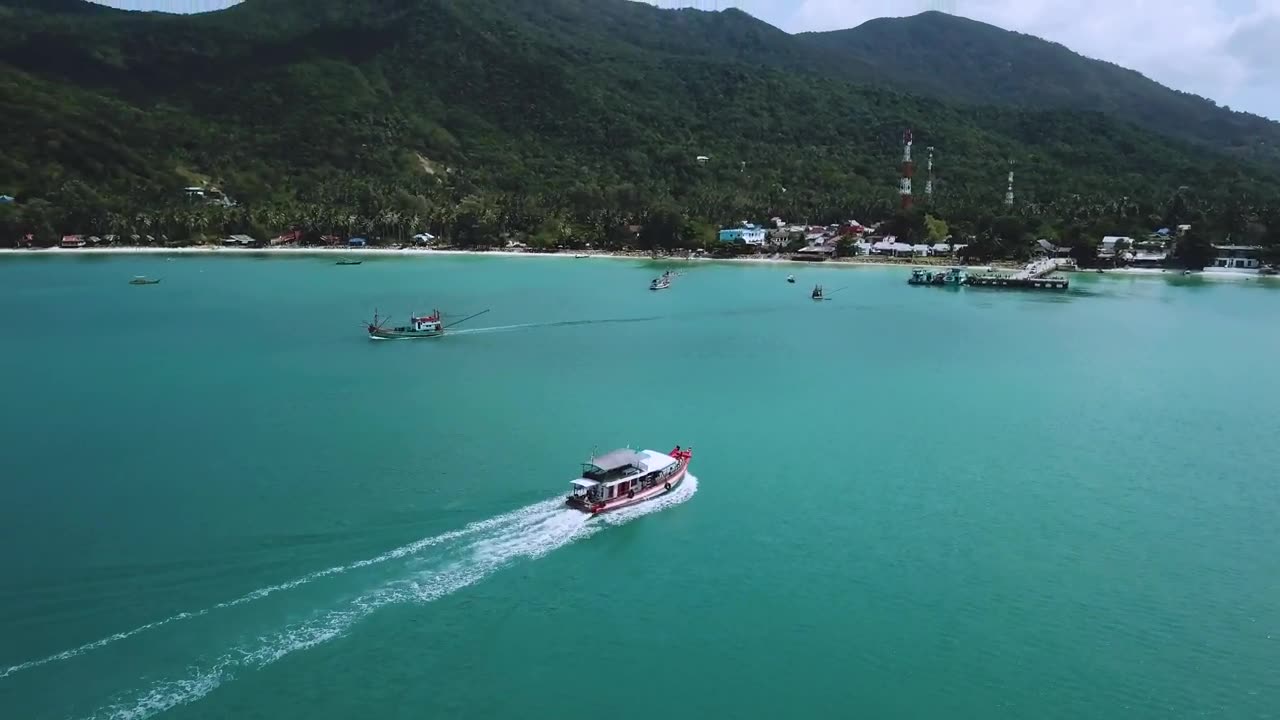 Beautiful coast with motorboats and a pier seen from the air