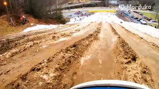 Man sleds on a dirt snow slope and falls off tube