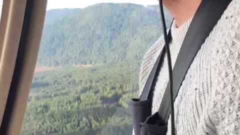 Happy guy flying a helicopter over Stave Lake
