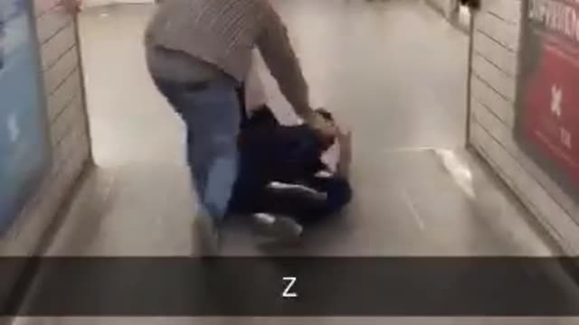 Two guys dragging another one through a subway station