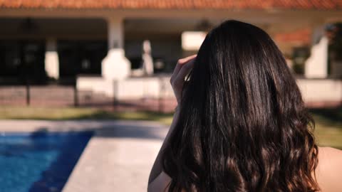 Women walks beside a swimming pool