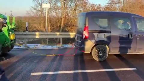 🚨WATCH: #German ecology activist tried to tow one of the farmer's tractors with his Dacia