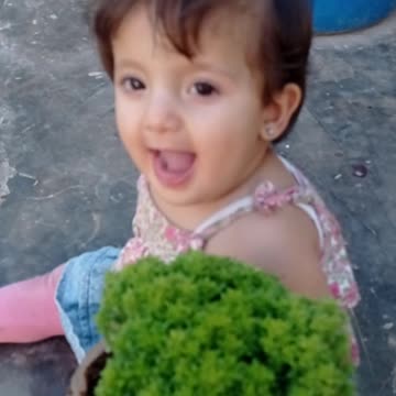 A wonderful little girl listening to the smell of basil