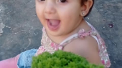 A wonderful little girl listening to the smell of basil