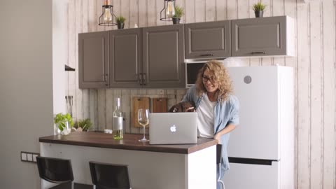 A Woman Engaged in a Video Call While Playing with the Cat