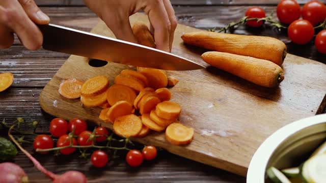 A Person Slicing Up the Carrots by Using a Knife