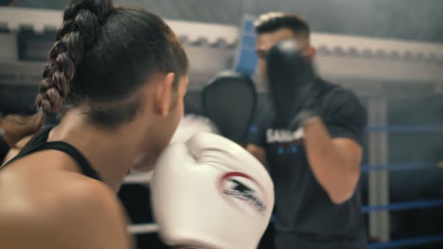 Woman doing kickbox movements with a coach