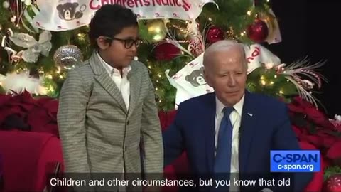 Biden trying to get a kid to sit on his lap...