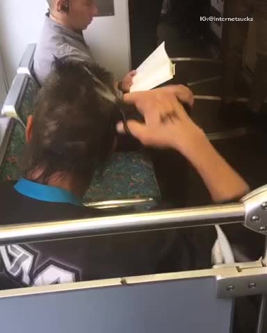 Man cutting hair with scissors on train