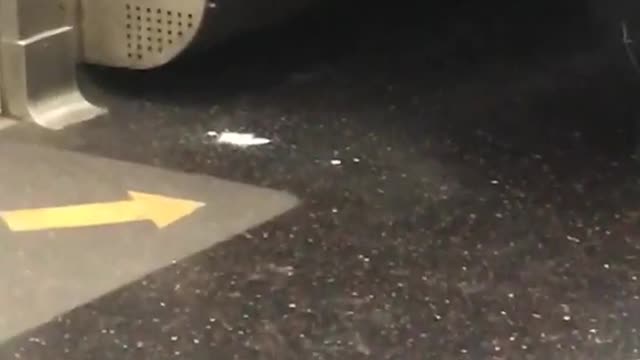 Man subway leaking white fluid liquid out of corner of jacket