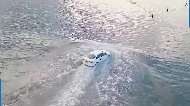 TAXI DRIVER STEERS THROUGH THE MID SEA