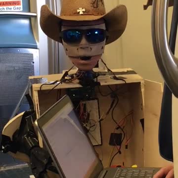 Robot with cowboy hat controlled by laptop subway
