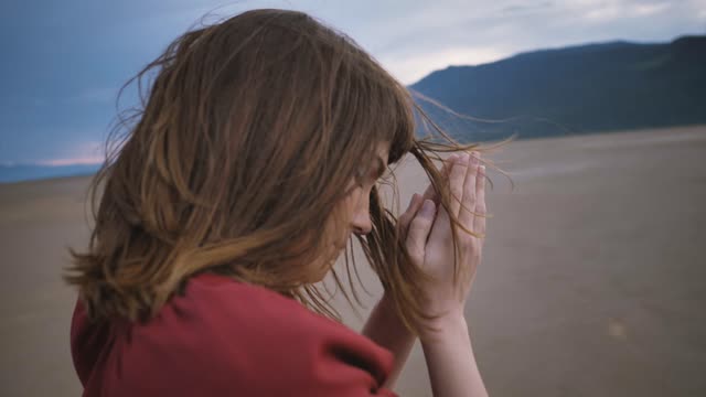 Young woman meditating in prayer pose in the middle of a desert