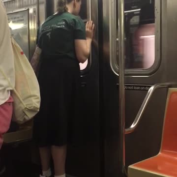Guy green shirt pony tail staring at subway door