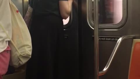 Guy green shirt pony tail staring at subway door