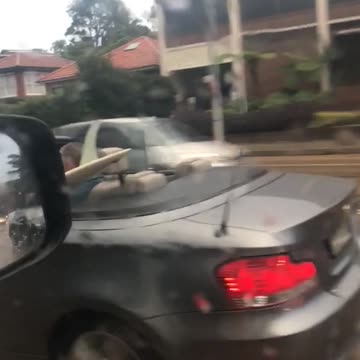 A man in grey car top down with surf board