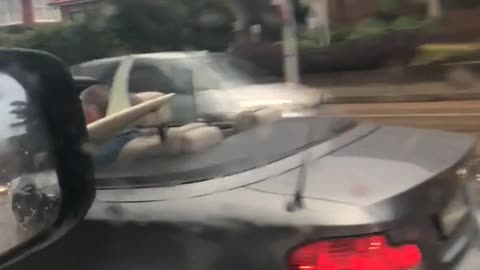 A man in grey car top down with surf board