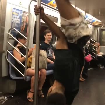 Guy dancing spinning subway pole music