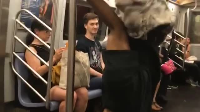 Guy dancing spinning subway pole music