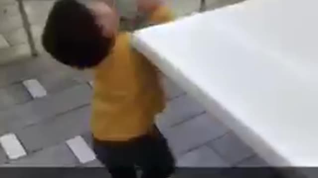 Tiny boy in yellow shirt hits head on table